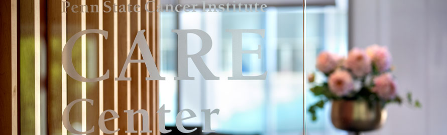 The lettering on the glass entry doors identify the CARE Center. Visible in the background is the wood detail of an interior wall and a large floral display.